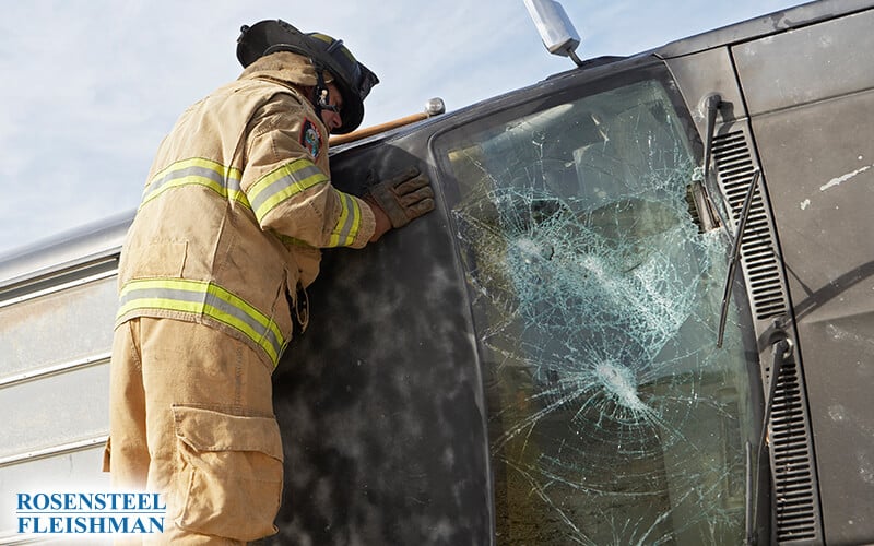 Firefighter Assisting at a Car Accident with a Damaged Windshield